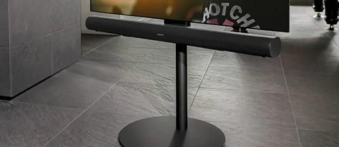 Soundbar is suspended below the TV by means of a TV stand.
