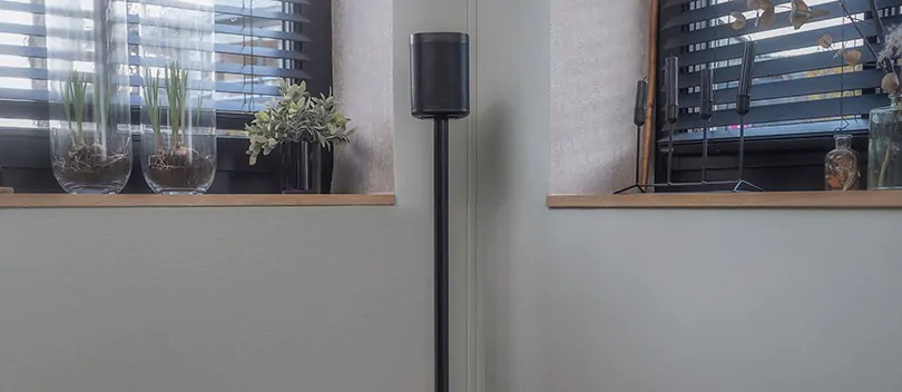 Multiroom speaker on speaker stand in living room.